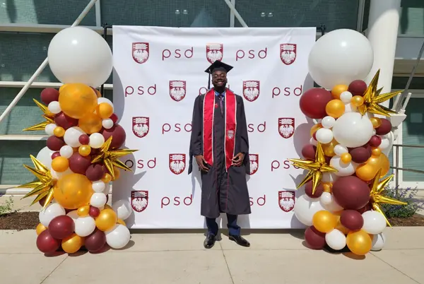 Balloon columns flanking a step and repeat with a graduate in front.